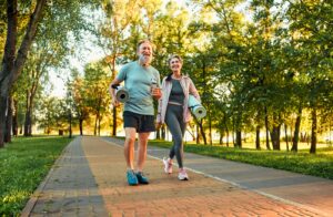 Older couple walking with yoga mats to help leg swelling in Portland, OR