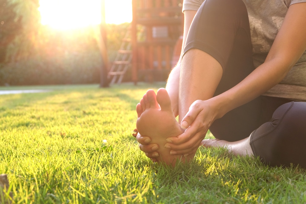 Woman holding her leg due to burning or tingling from vein issues