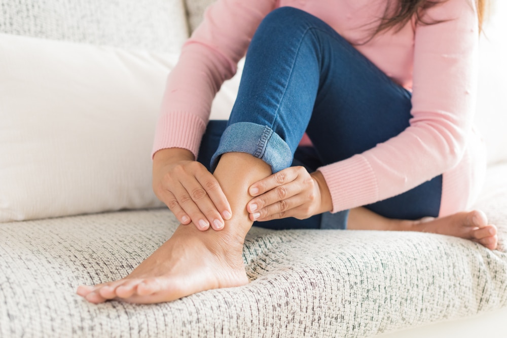 Woman holding her leg in pain due to a venous leg ulcer in Portland, OR